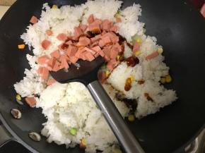 接着倒入米饭和火腿粒。