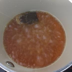 转中火煮5分钟左右离火（边煮变用勺背按压红茶包）。