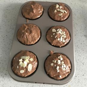 再继续放入面糊填满整个模具，用勺子压实。表面撒杏仁片装饰