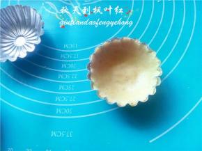 取一个面团，手上沾点油，将面团按压入涂抹了油的模具里。