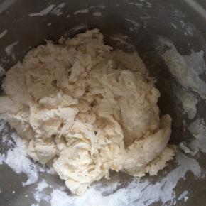 将酵母用温水化开，面粉中，加入盐、糖、玉米油，水用筷子搅拌成絮状。