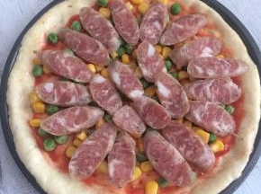 撒上豌豆和玉米粒，再铺上香肠片。