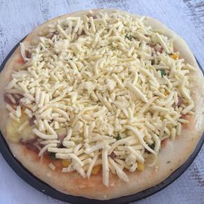 15分钟后取出披萨，再多撒一层芝士碎,