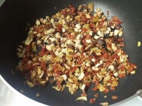 再加入腊肠，炒出香味才放花菇，炒熟。