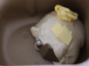 揉至面团光滑后，加入黄油，继续揉。