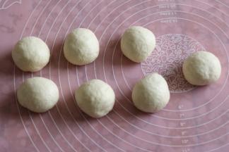 取出面团，挤压排气，把面团平均分成7等份。滚圆，保鲜膜覆盖松弛十分钟。