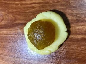 按扁面团，放入凤梨馅球，包好