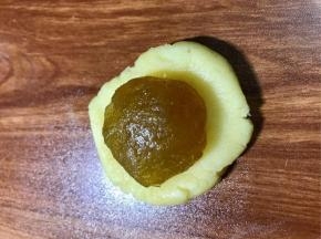 按扁面团，放入凤梨馅球，包好