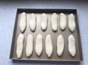 收口朝下，放在烤盘中，稍微拍扁