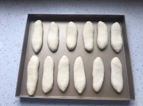 收口朝下，放在烤盘中，稍微拍扁