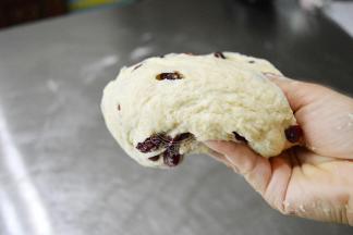 下面我们要开始摔面团了，拿面团的姿势如图，下面四个手指托住面团，大拇指轻捏。不要太用力的抠进面团