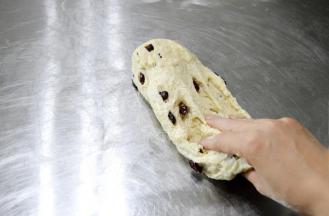 在空中顺时针画圈式的将面团甩出摔在操作台上。要注意掌握用力的方法，其实并不需要多大力气，主要是利用空中画圈后落下的惯性。