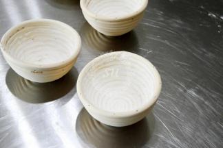 在发酵藤篮中倒入面粉，转动藤篮，让面粉均匀的附着在藤篮上