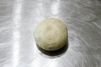 收紧面团。对于欧包来说，收紧面团使面团的表面绷紧非常重要。如果没有收紧，割包后面团就会瘫掉。收紧的面团收口向上放入藤篮。