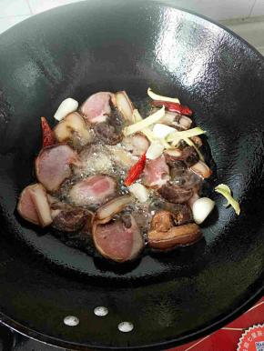 铁锅放入油，烧热加入腊肉，蒜，姜，干辣椒爆香。