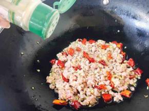 然后放入肉末，用铲子把肉末打散，翻炒几下，肉末变色后加入少许白胡椒粉和少许料酒且翻炒均匀。