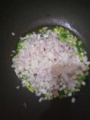 锅内倒油，先倒入葱爆香，再倒入洋葱粒。