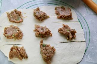 把肉馅分成8份放在面片上（最下角那一个位置不要放）