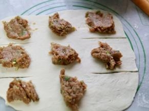 把肉馅分成8份放在面片上（最下角那一个位置不要放）