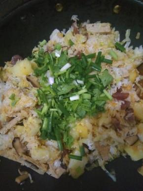 再倒入煮好的土豆饭，伴匀，淋入少许酱油调味，加葱花