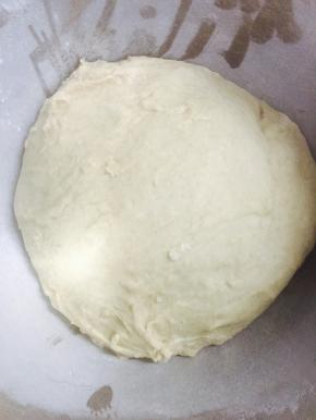 等面团再次成团不太粘的时候取出放入撒有少量高粉的打蛋盆
放在烤箱里发酵，放入一碗热开水。