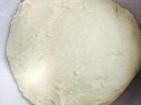 等面团再次成团不太粘的时候取出放入撒有少量高粉的打蛋盆
放在烤箱里发酵，放入一碗热开水。