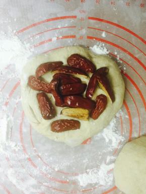 面团压扁排气，包入之前准备好去核儿的红枣，像包包子一样给它包起来