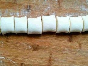 面团发酵好以后，排气，重新揉至光滑。切开无气孔，平均分成两份，取其中一份搓长，平均分成八份。