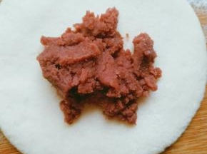 取其中一块面团，擀成中间厚边上稍薄的面皮，放入适量的豆沙馅(擀皮不要太薄影响发酵)