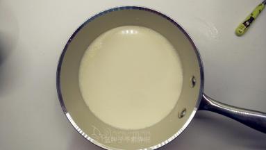 牛奶和淡奶油混合均匀之后，加入糖粉，小火加热到40摄氏度左右，直到糖粉融化。