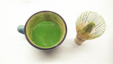 倒适量加热好的牛奶淡奶油（约100g）到抹茶粉中，用茶筛将它们混合均匀，尽量混匀到看不见抹茶颗粒。