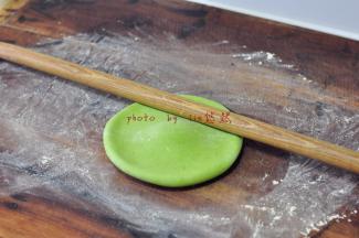 用擀面杖先将一圈的边往开擀，边擀边转，面团成中心高边子低薄的状态。