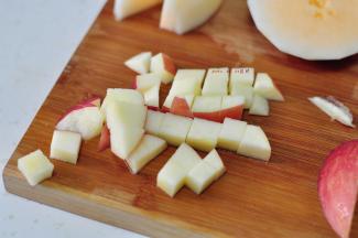 苹果也切粒，果粒和苹果粒拌在一起，撒上适量炼奶，然后用黄瓜片装饰，放上薄荷叶即可。