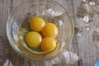 玻璃碗里加入分离三个蛋黄一个全蛋，总手抽打匀。