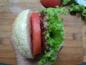 放一层生菜，夹上牛肉饼，挤上沙拉酱，再放一层西红柿，再加一片生菜叶，再挤上沙拉酱。完成。