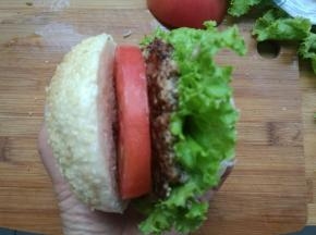 放一层生菜，夹上牛肉饼，挤上沙拉酱，再放一层西红柿，再加一片生菜叶，再挤上沙拉酱。完成。