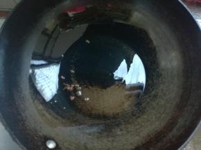 炒锅坐火，锅热放油，放几粒花椒至微微变色。