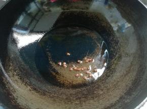 炒锅上火，锅热倒油，下入几粒花椒炸香。