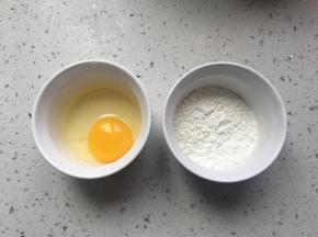 将刚才腌鸡肉剩下的鸡蛋打在碗里，淀粉准备好，面包糠准备好