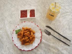 盘子上垫张吸油纸，将炸好的鸡米花控油放入盘中，配上自己喜欢的蘸酱就可以吃了