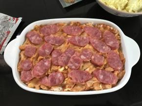 5、把拌好的山药泥放入烤碗，铺上一层香肠。