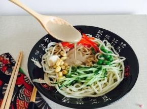 在晾凉的面上浇上几勺芝麻酱汁和几小勺花椒油汁，再放些黄瓜丝，拌一拌，就着新鲜的大蒜吃，超级爽口。