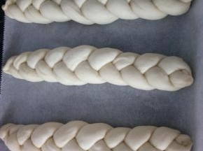 10.	依次编好三根辫子。放入烤盘，整理好形状和位置，开始二次发酵。