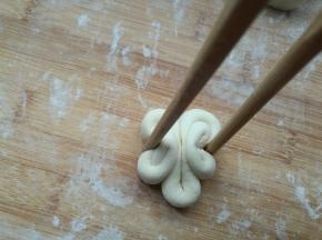 中间部分弯向自己身侧，用筷子向两个圆圈中间夹一下。