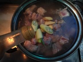 入冷水锅加入葱姜（方子内取一半）料酒煮沸撇去血沫