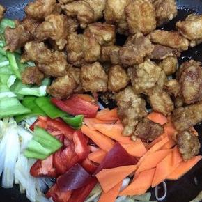 然后放入青红椒、胡萝卜和炸好的肉倒入翻炒片刻