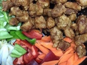 然后放入青红椒、胡萝卜和炸好的肉倒入翻炒片刻