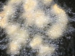 炒锅里倒入适量的油，等油温七成热时，下入肉块炸