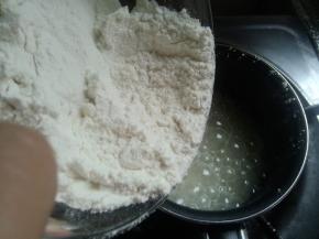 玉米油小火煮沸，加入过筛的低筋面粉。（图中泡泡不是玉米油煮沸了，是放进去了一点面粉导致泡泡）