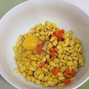 将玉米粒、胡萝卜和火腿肠装入碗中，加入鸡蛋，搅拌均匀